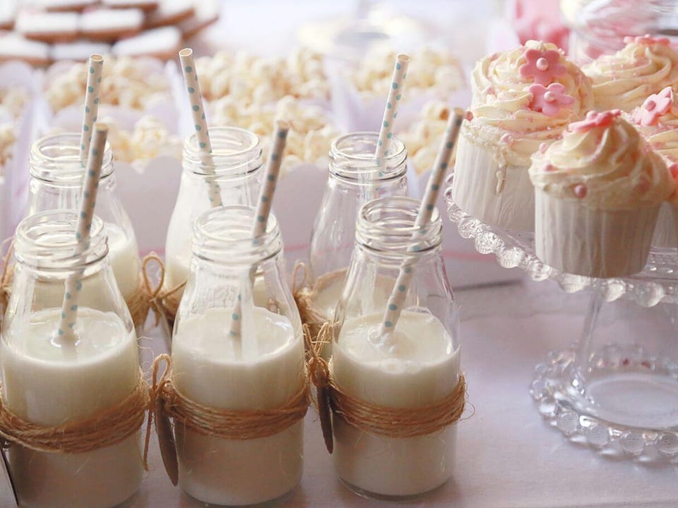 Vasitos de batido junto a cupcakes artesanales