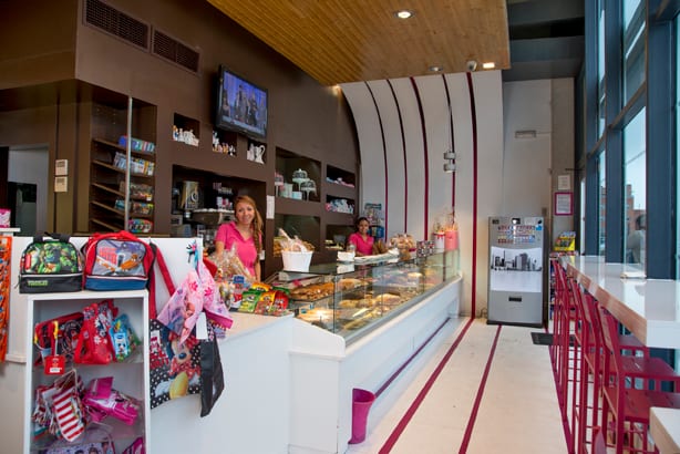 El mostrador de Miramadrid: la vitrina larga, los expositores, el techo de madera y las rayas magenta del suelo