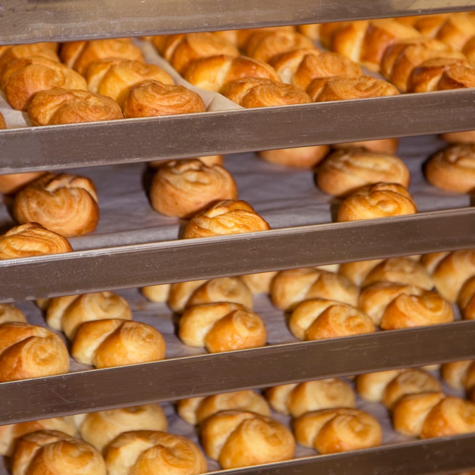 Carro del obrador lleno de croissants recién horneados