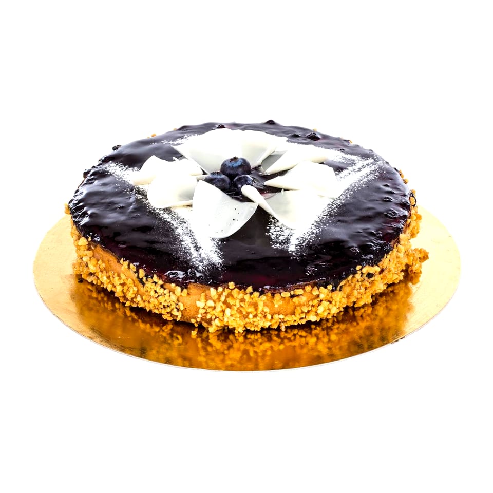 Tarta de queso y arándanos entera, con la gelatina oscura por encima y el lateral cubierto de almendra granillo