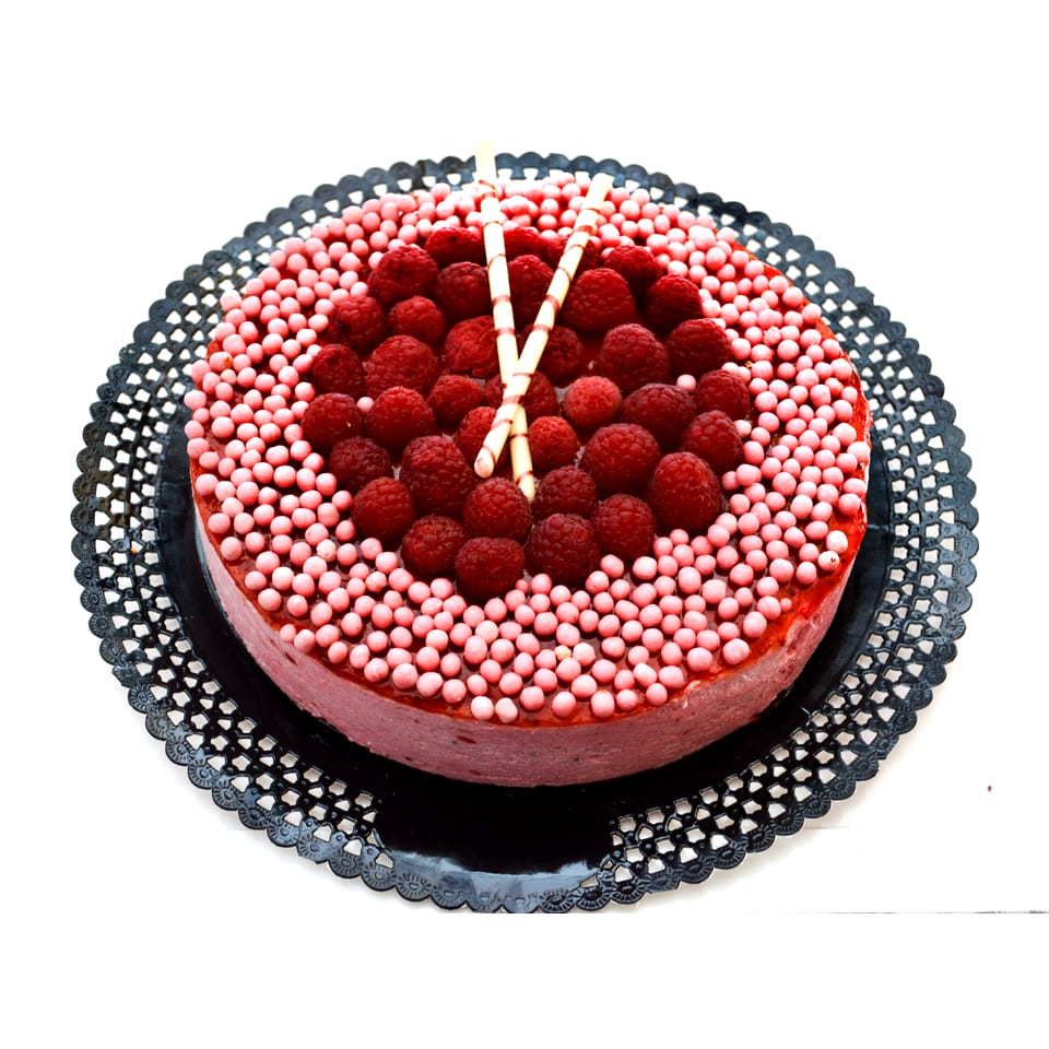 Tarta mousse de frambuesa entera: el disco de frambuesas frescas en el centro y el anillo de perlas rosas alrededor
