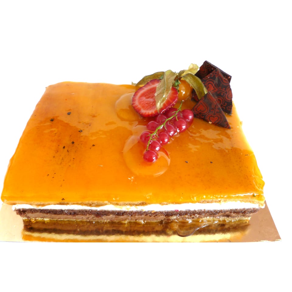 Tarta San Marcos entera: la yema confitada y tostada por encima y, en el corte lateral, las capas de bizcocho, nata y trufa